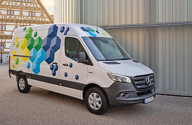 A white Mercedes Benz eSprinter van with painted with colourful geometric shapes