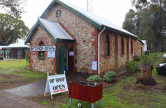 An old stone building with an op shop sign across the front