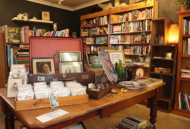 A table full of goods with shelves full of books in the background