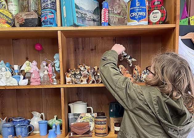 A woman arranges ornaments on a shelf
