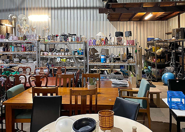 Shelves full of goods inside an op shop inside a shed
