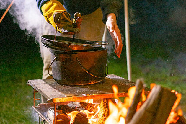 Food cooking in a pot over a campfire
