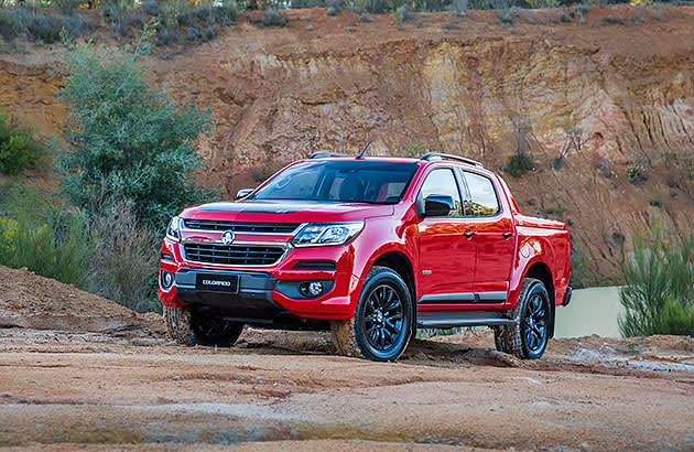 Red Holden Colorado ute against parked in front of a rock face.