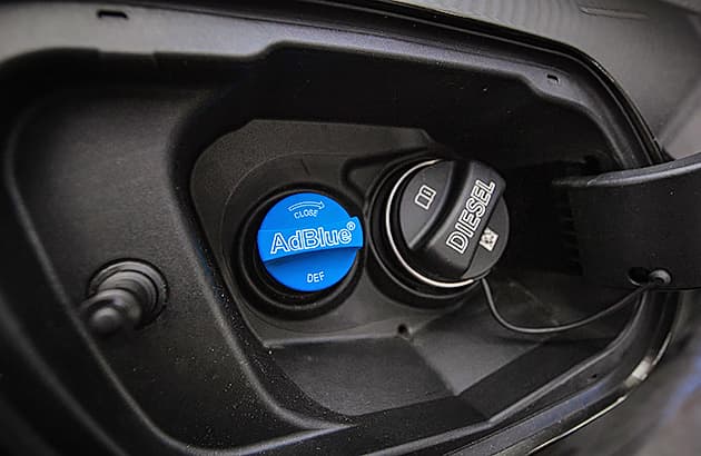 A close up of AdBlue and diesel filler caps on a diesel vehicle