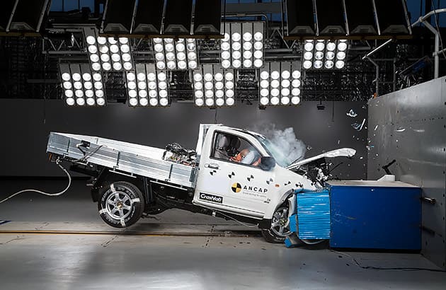 A white ute being crashed into a wall at an ANCAP crash testing facility