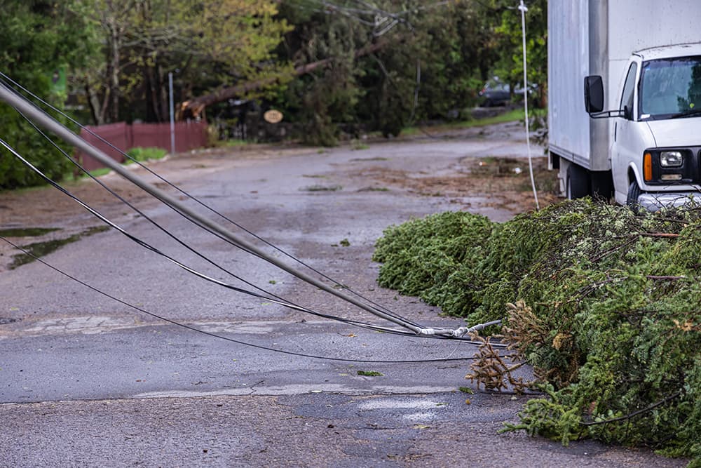 Wires from a fallen powerline lay across a road