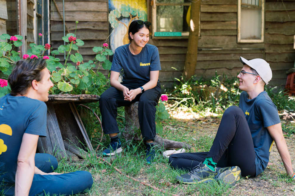 Three Ignite participants sat in the garden at the Ignite camp.