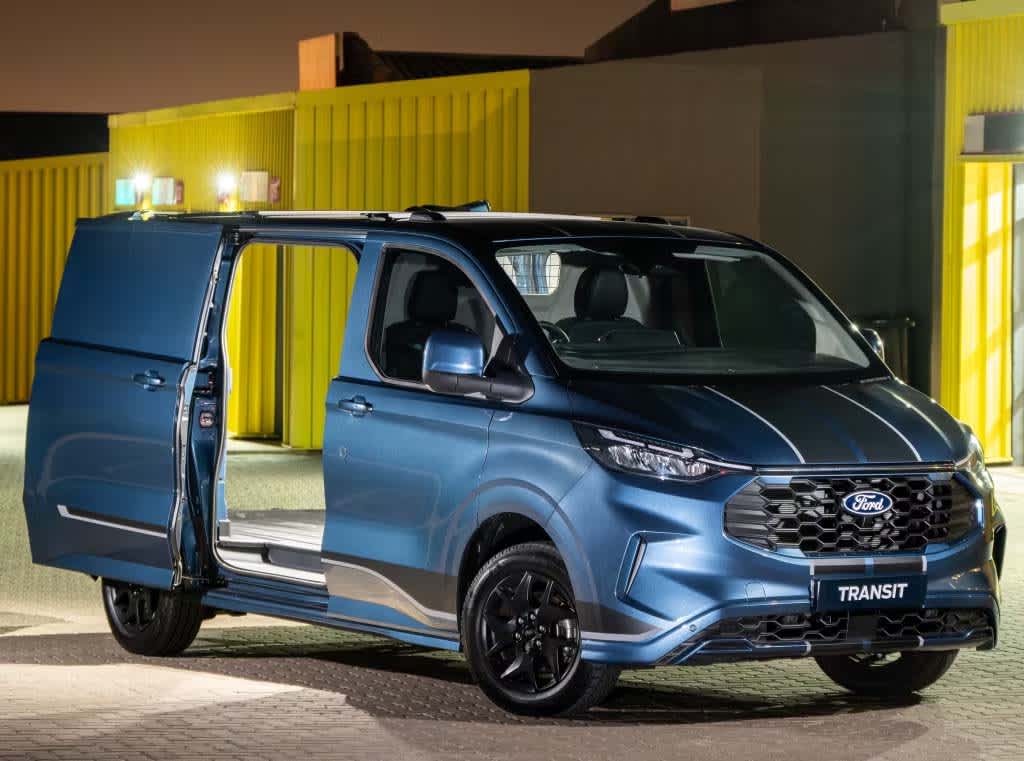 A blue Ford Transit Custom van near shipping containers