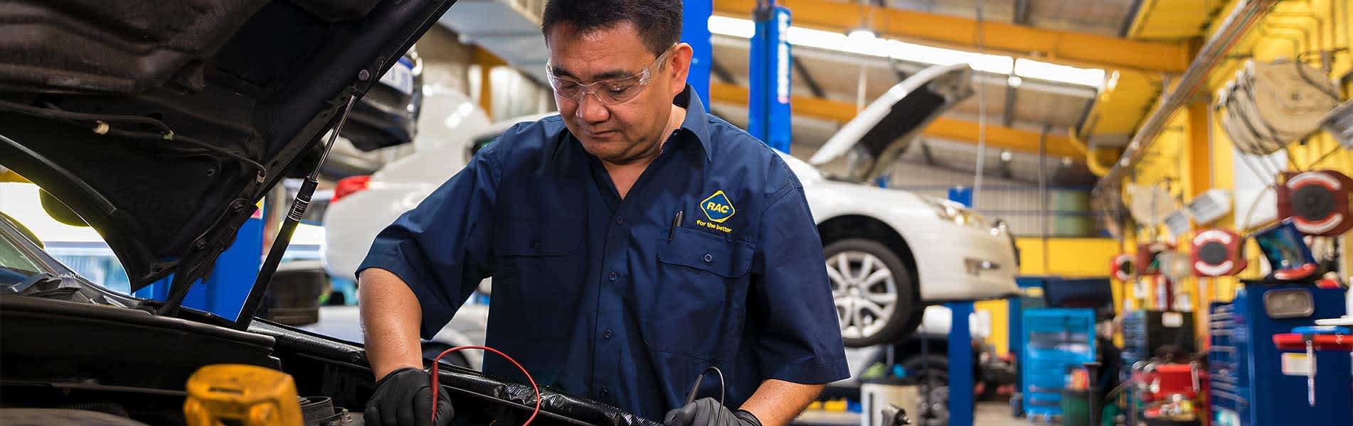 An RAC Auto Services mechanic inspects the engine of a car