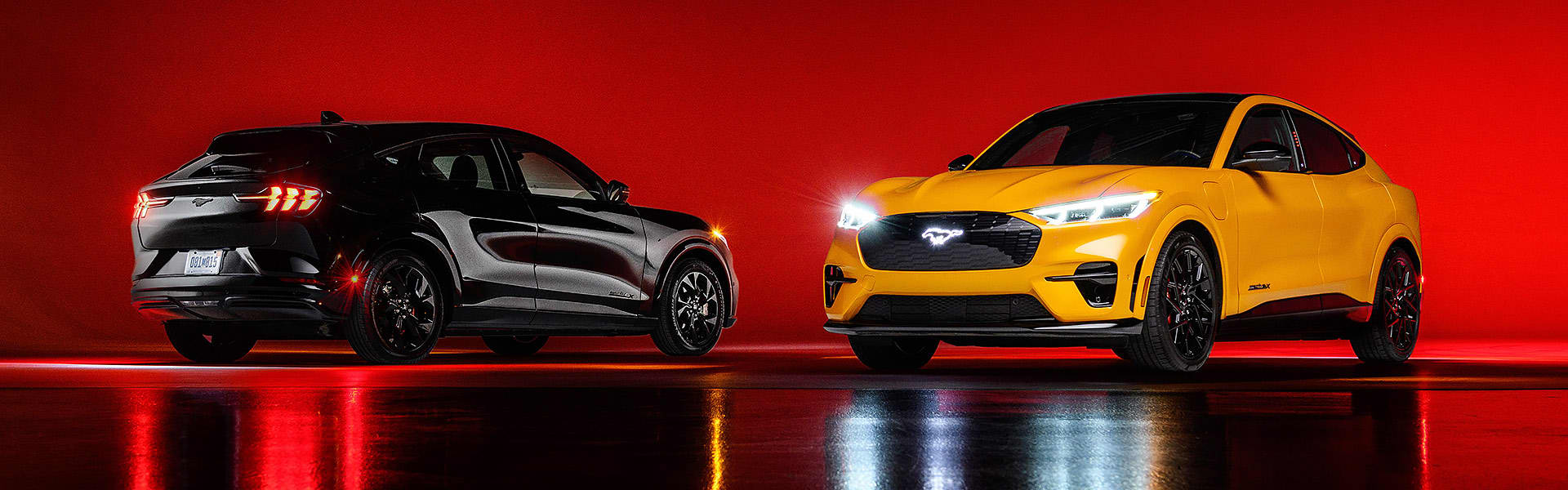Two Ford-Mustang-Mach-Es in a studio setting lit with red light