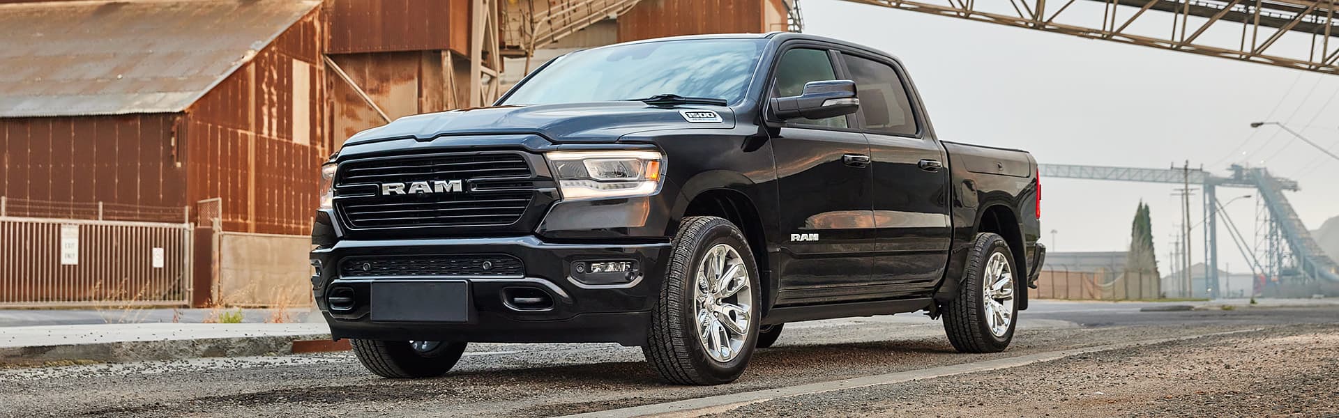 A black Ram Silverado on the road in an industrial area