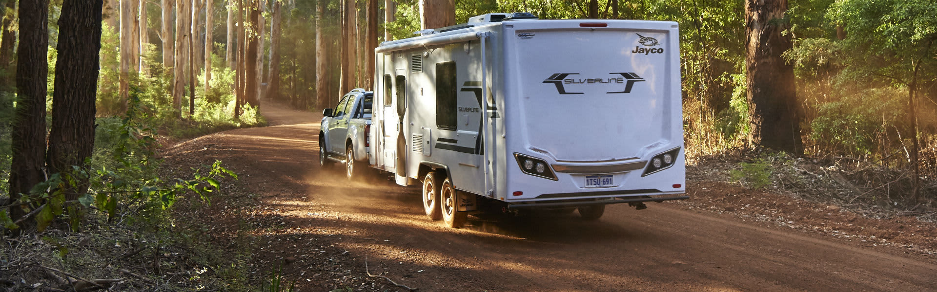 A 4WD towing a caravan through South West bush
