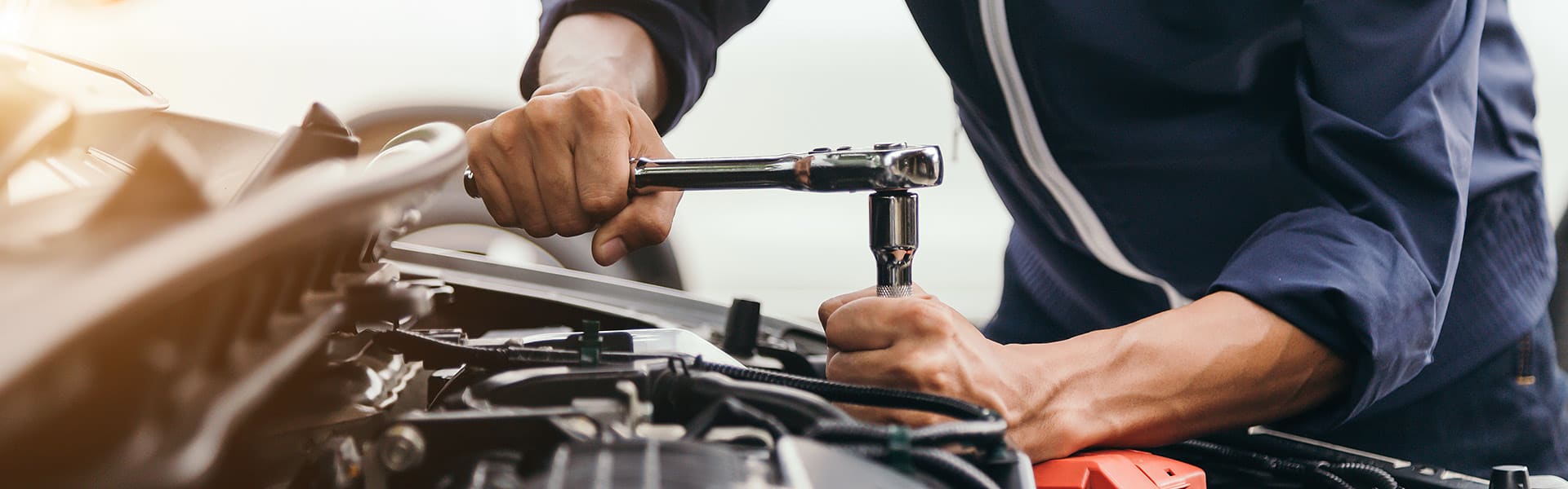 A close up of a person working on a car engine