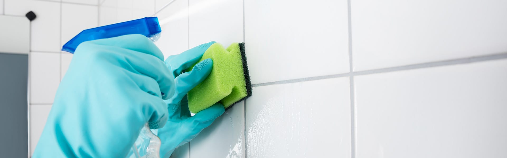 Person scrubbing bathroom tiles