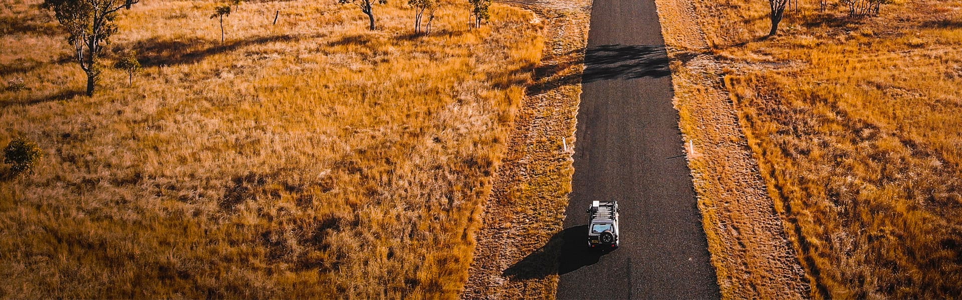 A four-wheel drive on a rural road in summer
