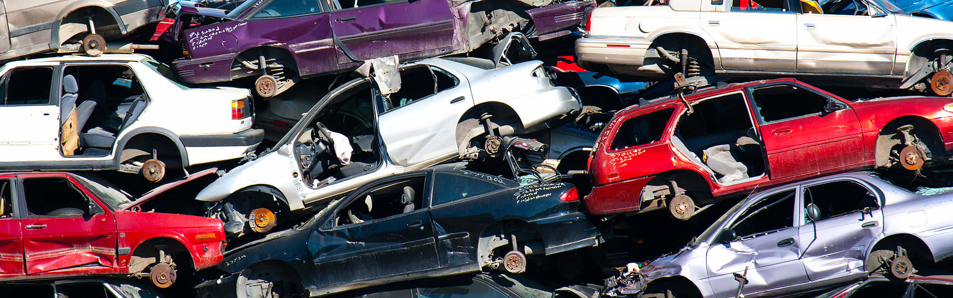 Old car bodies piled up in a wreckers yard