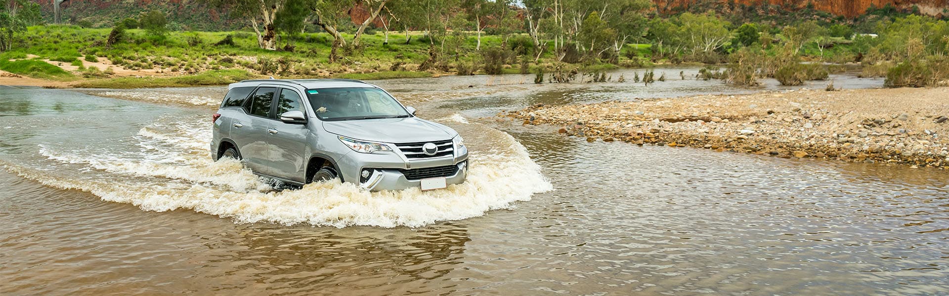 A four wheel drive crossing a body of water
