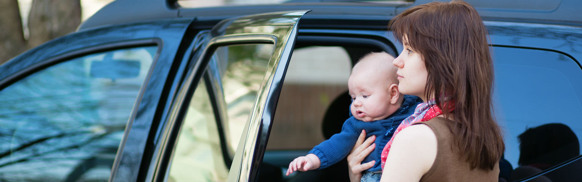 A mother putting her baby into the car
