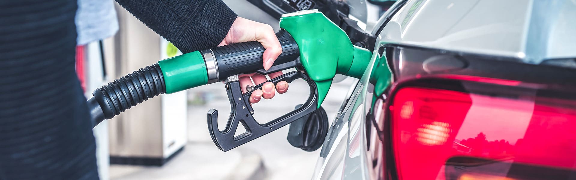 Close up of person pumping fuel into a car