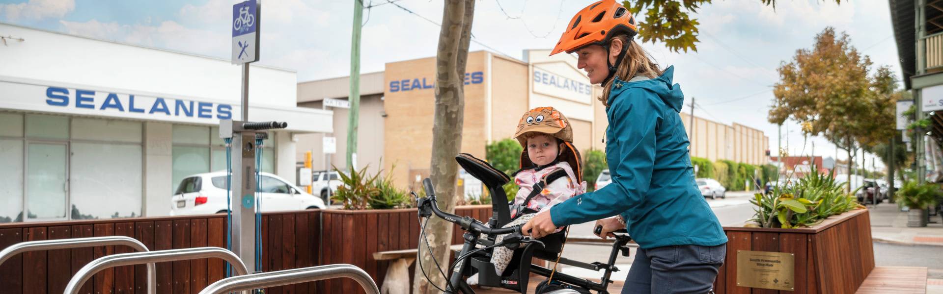 A mother and her young child dismounting their bike at the South Freo Bike Hub.