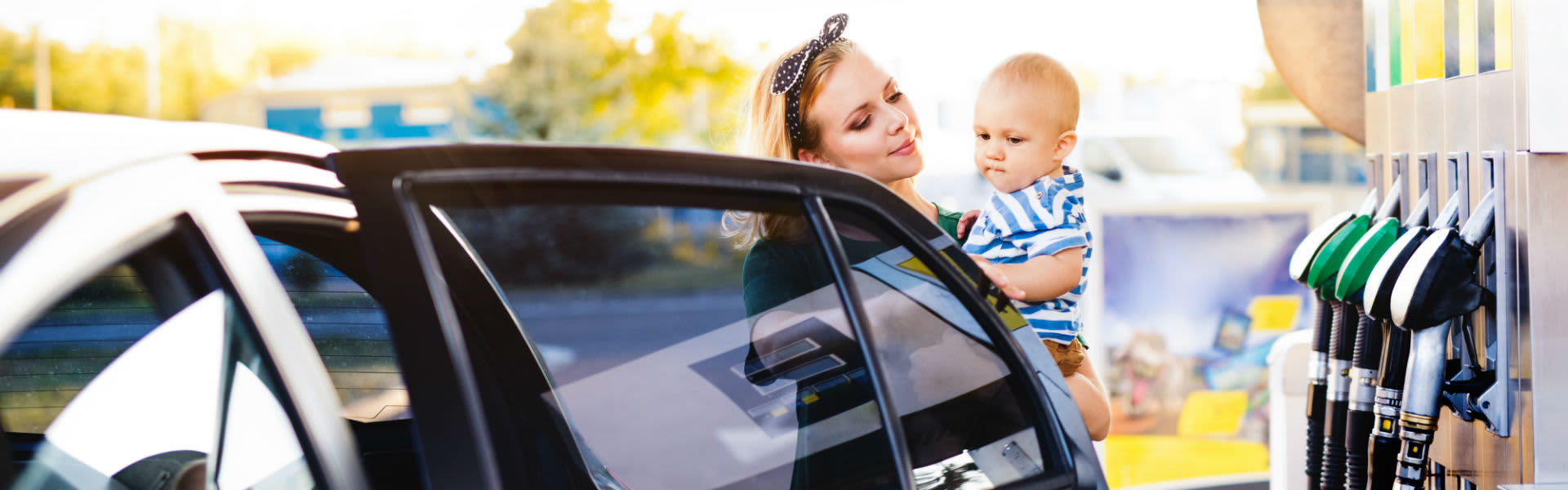 A mother holding her baby at a petrol station