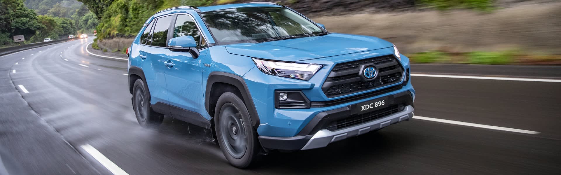 Blue RAV4 Hybrid driving on road