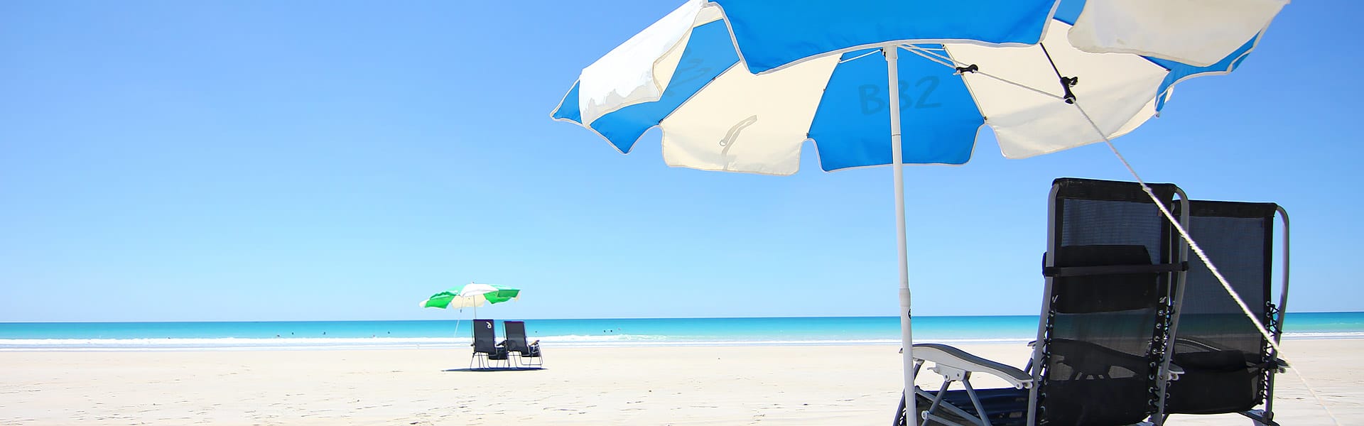 Two sets of umbrellas and chairs on Cable Beach