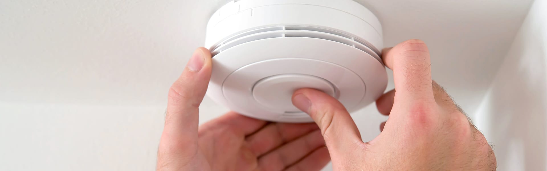 Image of man testing smoke alarm