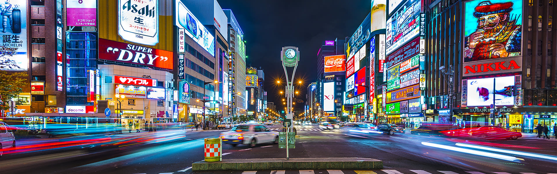 A busy Tokyo street at night with brightly coloured neon signs