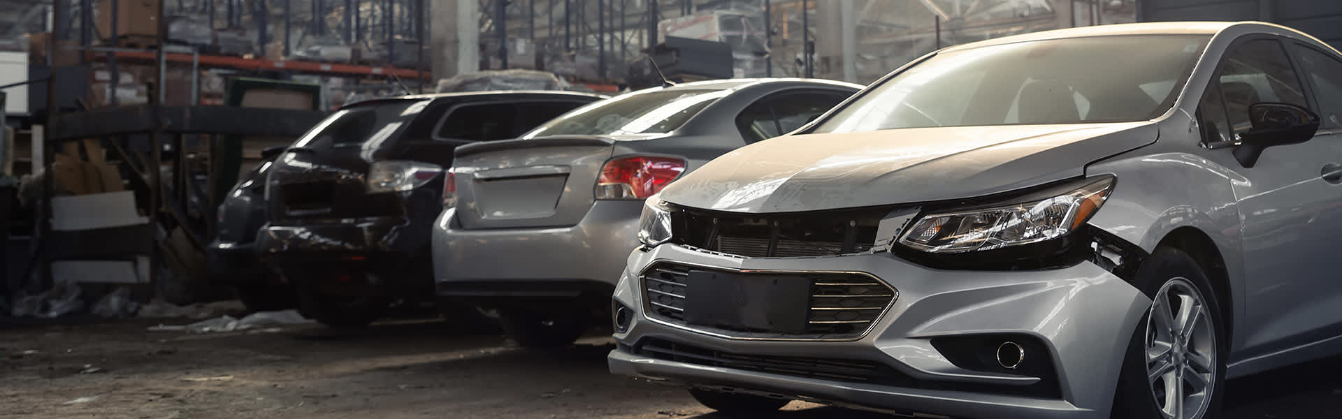 Wrecked cars inside a dark warehouse