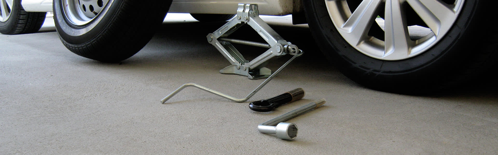 Tools for changing a tyre next to a white car
