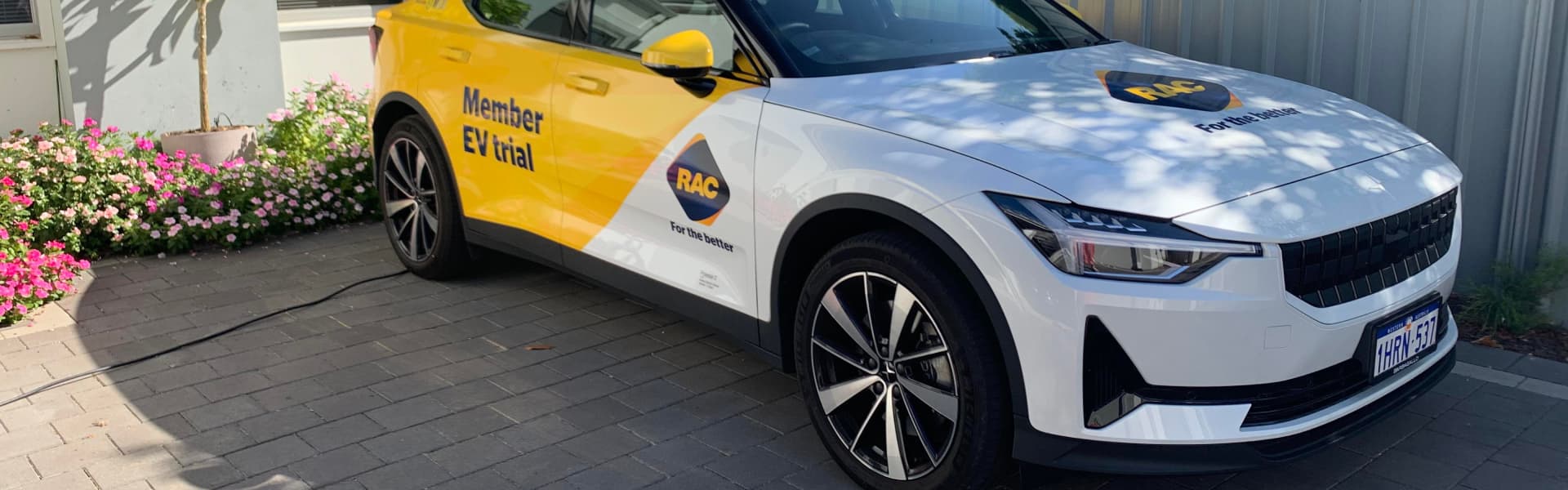 RAC branded Polestar 2 electric vehicle parked in driveway charging