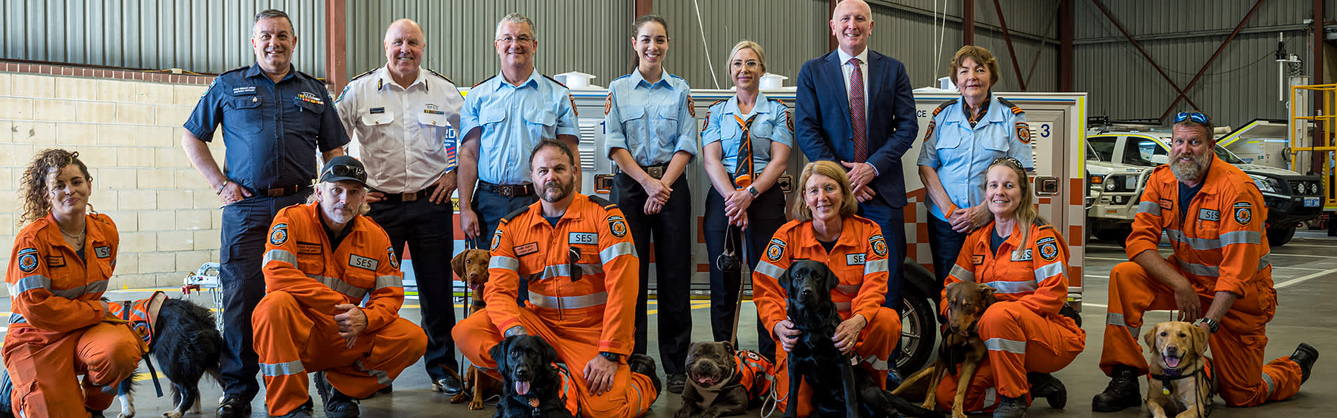 A group of canine rescue unit volunteers and their dogs pose for the camera