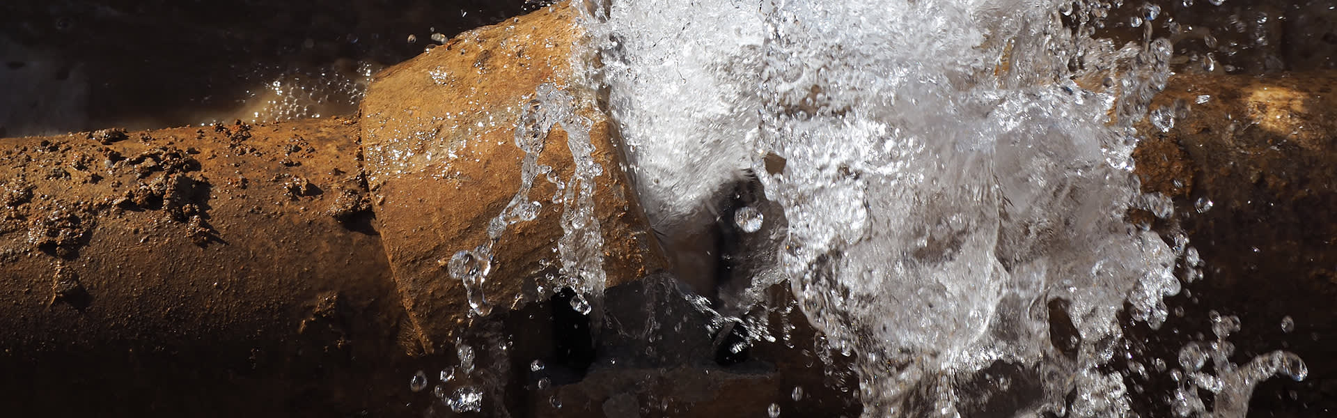 Burst water pipe with water flowing from it
