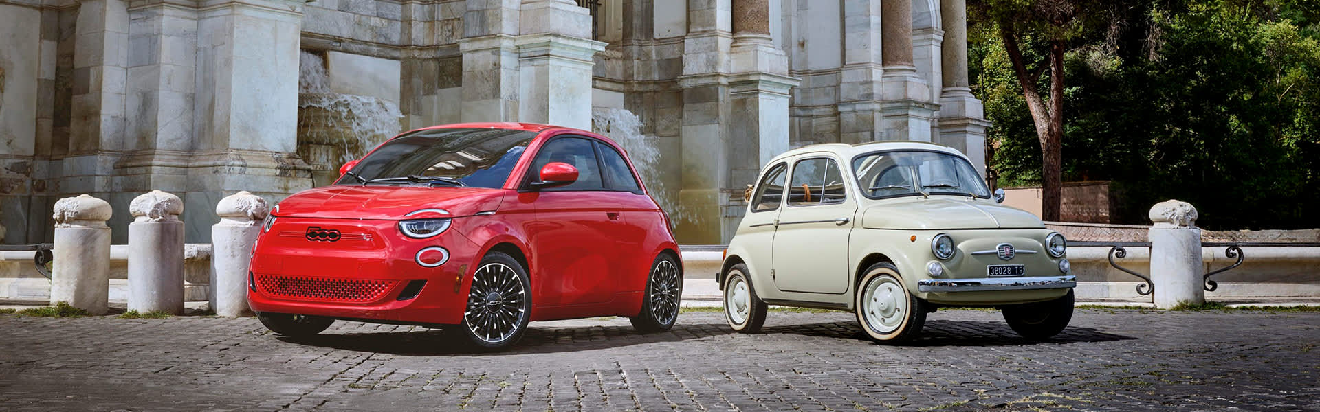 Fiat 500e parked alongside an original Fiat 500