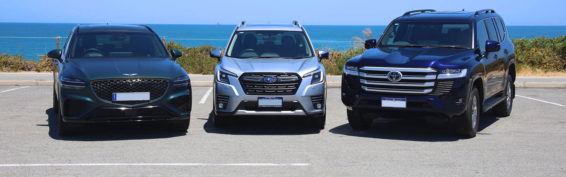 A Genesis, Subaru and Toyota car next to each other