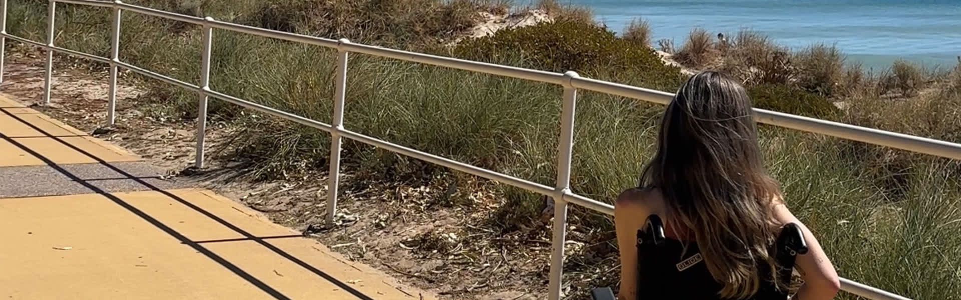A woman in her wheelchair on an outdoor trail
