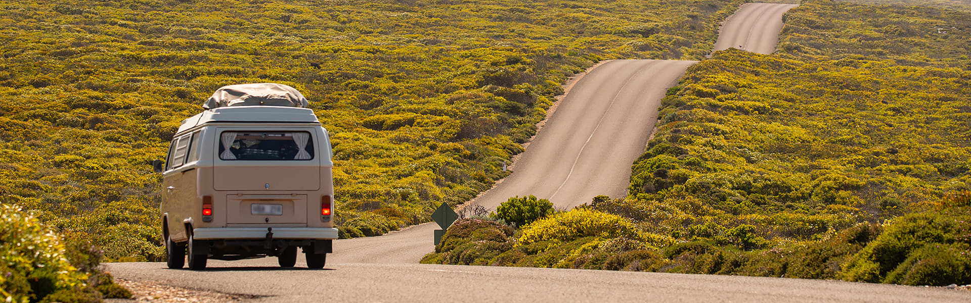 A VW Kombi van travelling down a winding road
