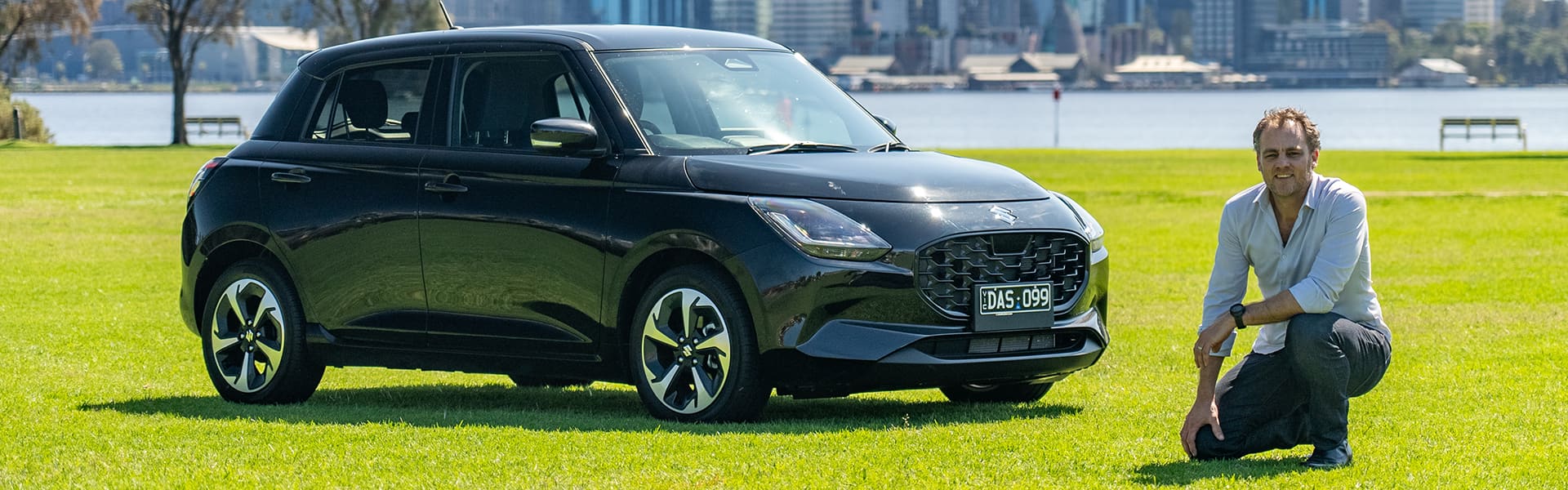 Alex Forrest posing with a black 2024 Suzuki Swift