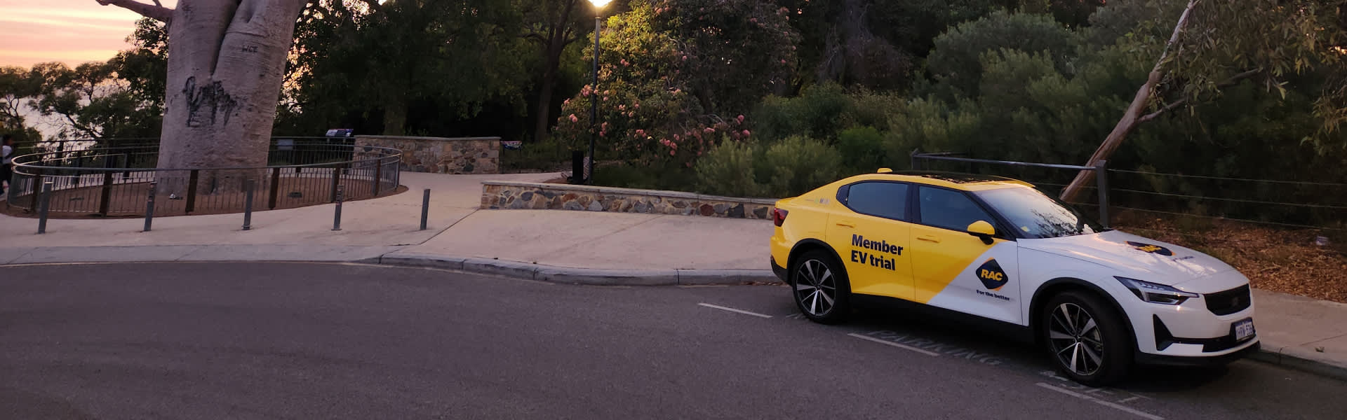 Yellow Polestar 2 electric car parked in Kings Park at sunset