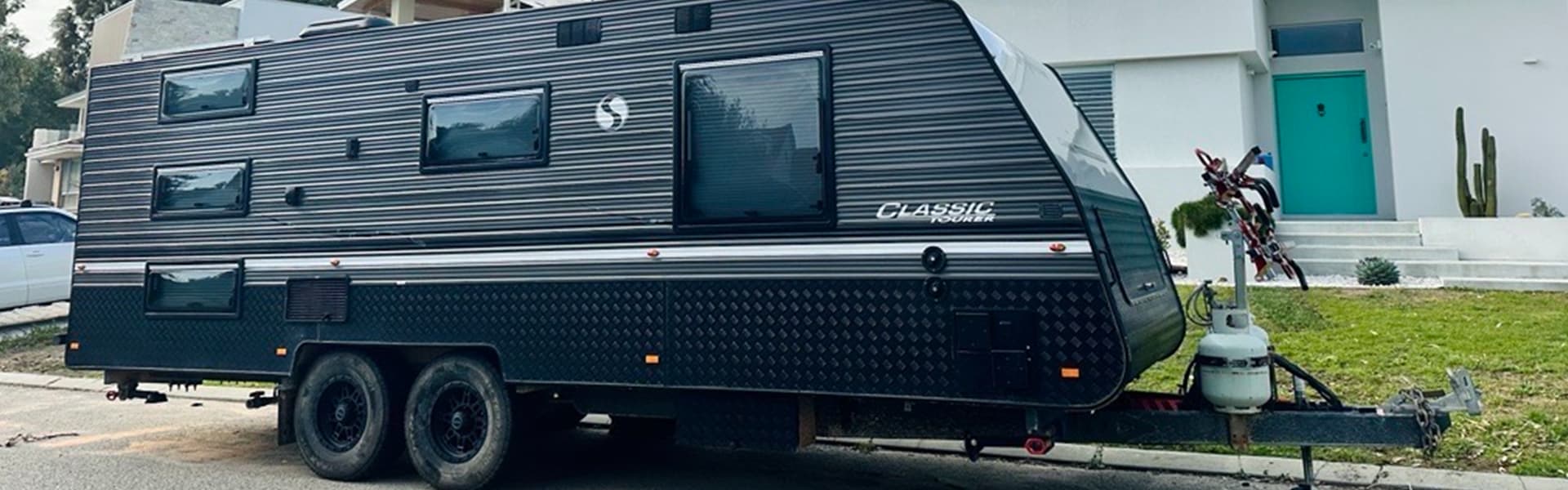 A caravan parked outside a home