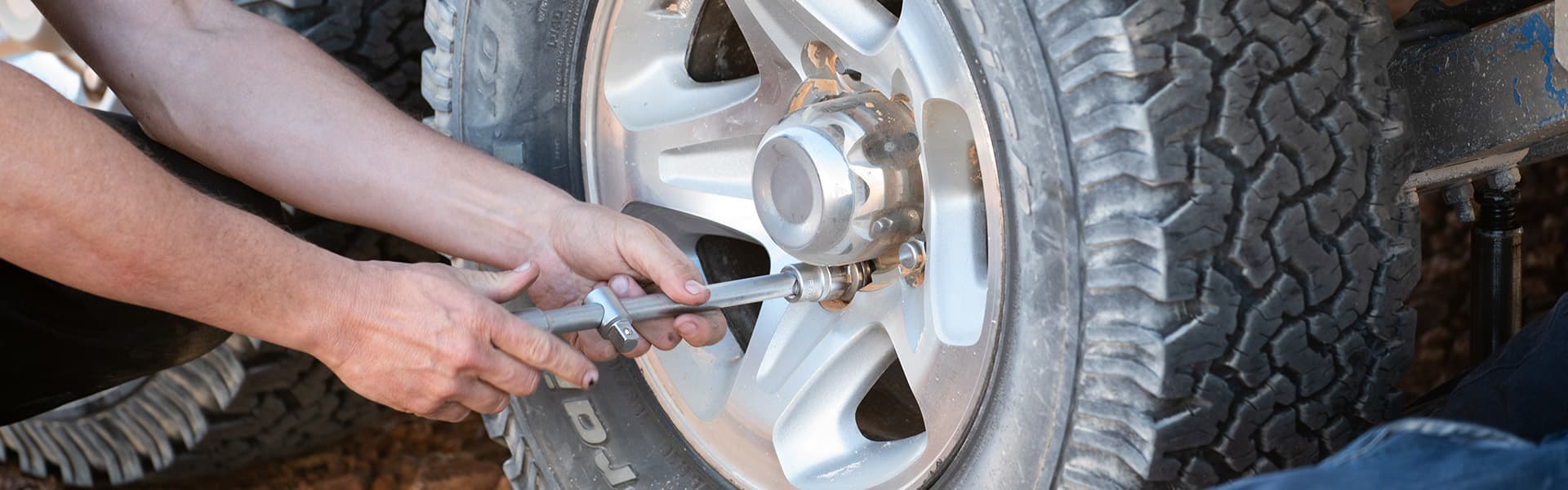 A person tightens wheel nuts on a caravan wheel