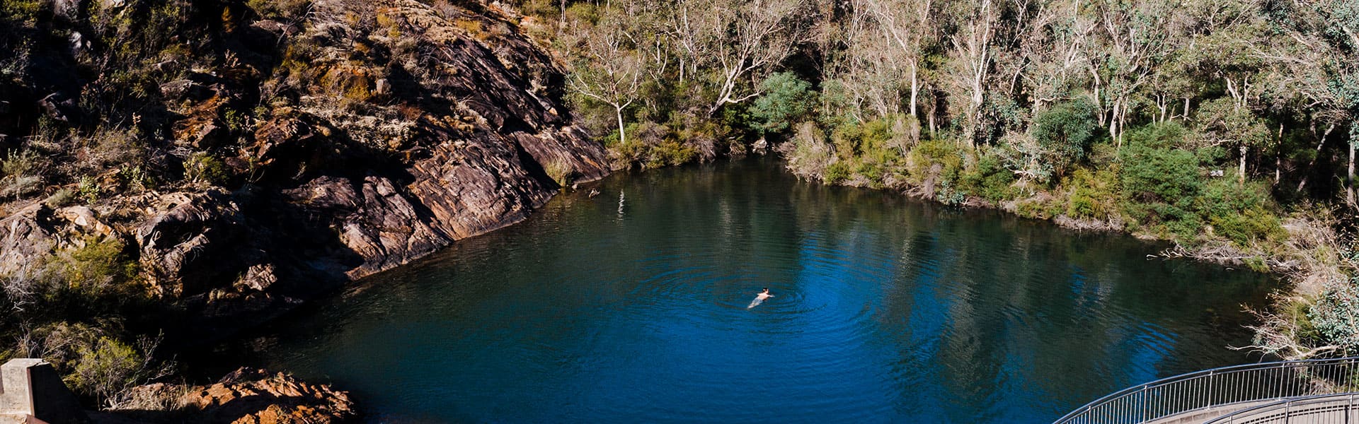 View of serpentine falls pool with person swimming