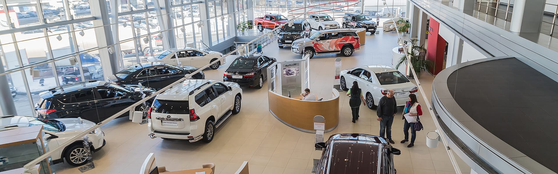 A car dealership showroom with people browsing cars