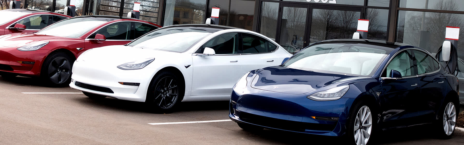 A row of Teslas on sale at a car dealership