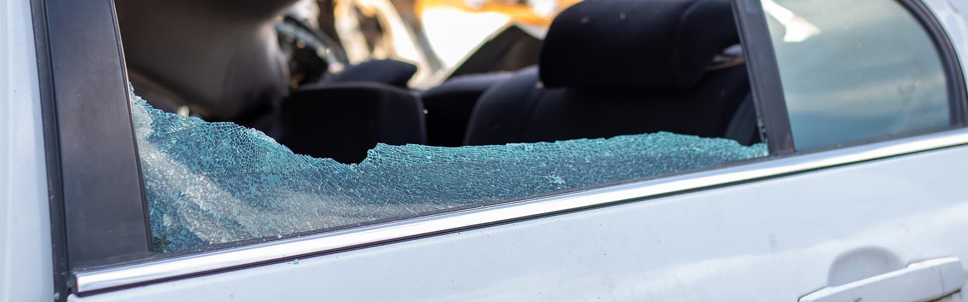 A shattered passenger seat window in a car