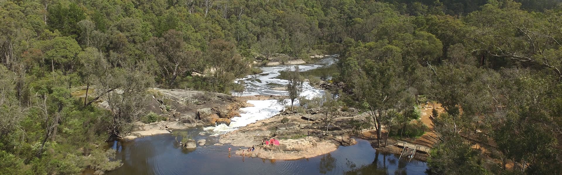 Overhead shot of campsite by a flowing river in Dwellingup.