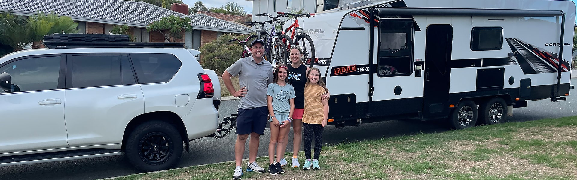 The Morrell family standing in front of their caravan