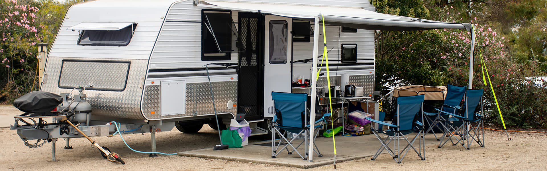 A caravan parked on a concrete pad with awning extended
