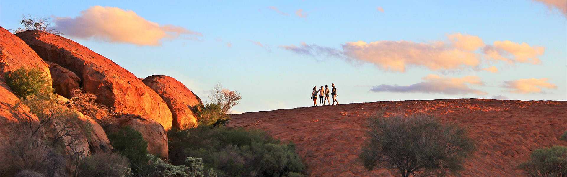 People walking near a rock
